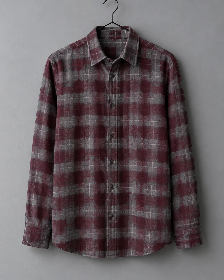 Camisa de franela a cuadros grises y burdeos colgada en una percha negra de metal
